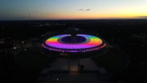 Dach des Olympiastadions in regenbogenfarben beleuchtet bei Sonnenuntergang