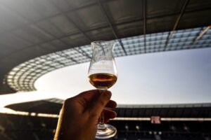 gefülltes Whiskyglas vor Dach des Olympiastadion Berlin