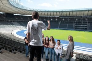 Tour Guide mit Gruppe im Innenbereich des Stadions